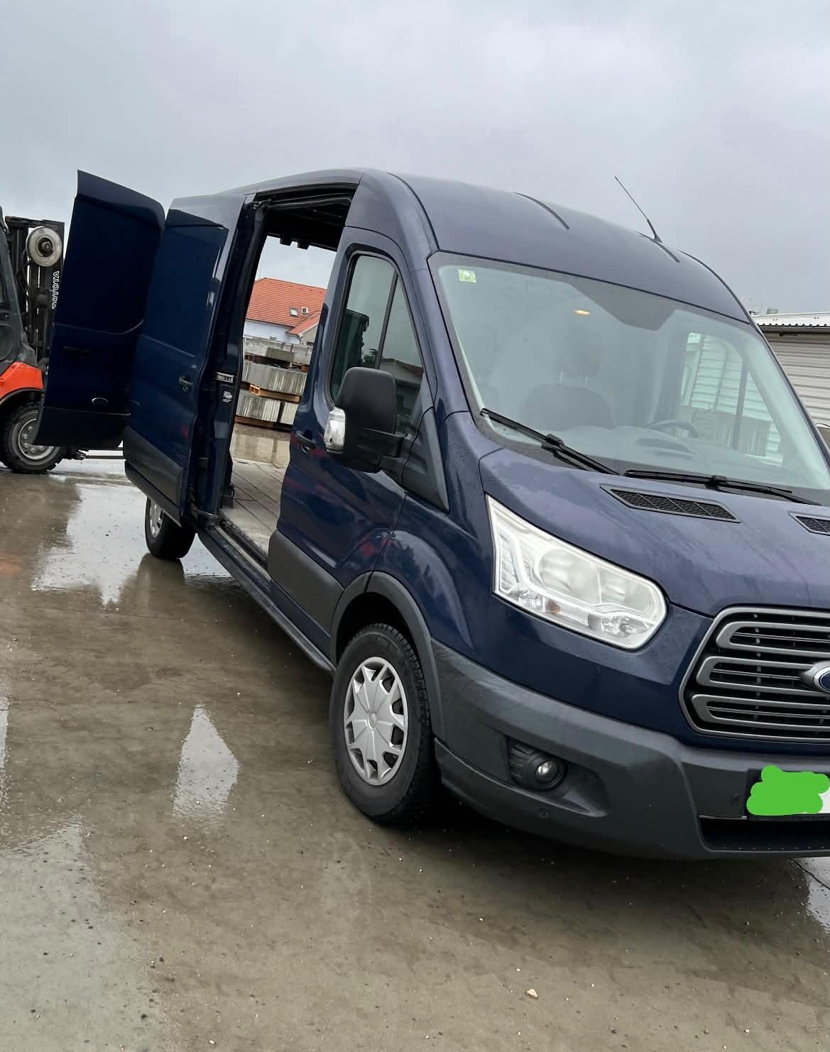 Modrá dodávka Ford Transit s otevřenými dveřmi připravená k odvozu a stěhování