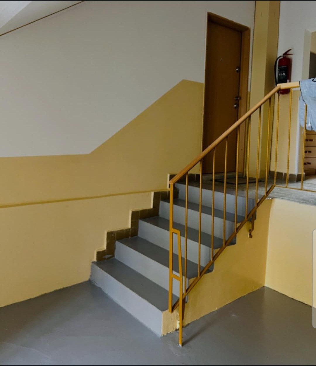 Hotová malba schodiště bytového domu s natřeným zábradlím